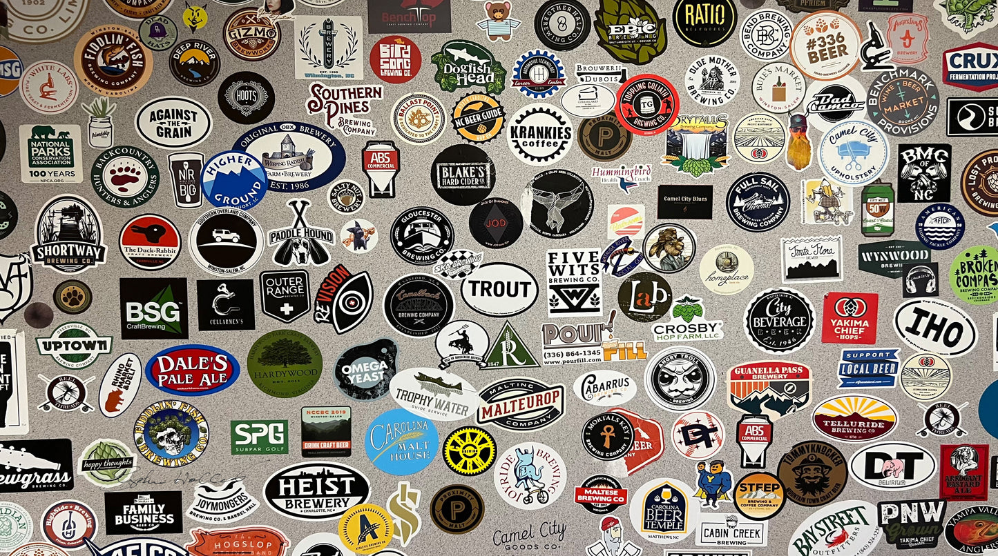 Various stickers of beer, coffee, music bands, and travel destinations as a SCÜPskin™ Deco-Sleeve for the PÜP SCÜP™ litter scoop caddy.